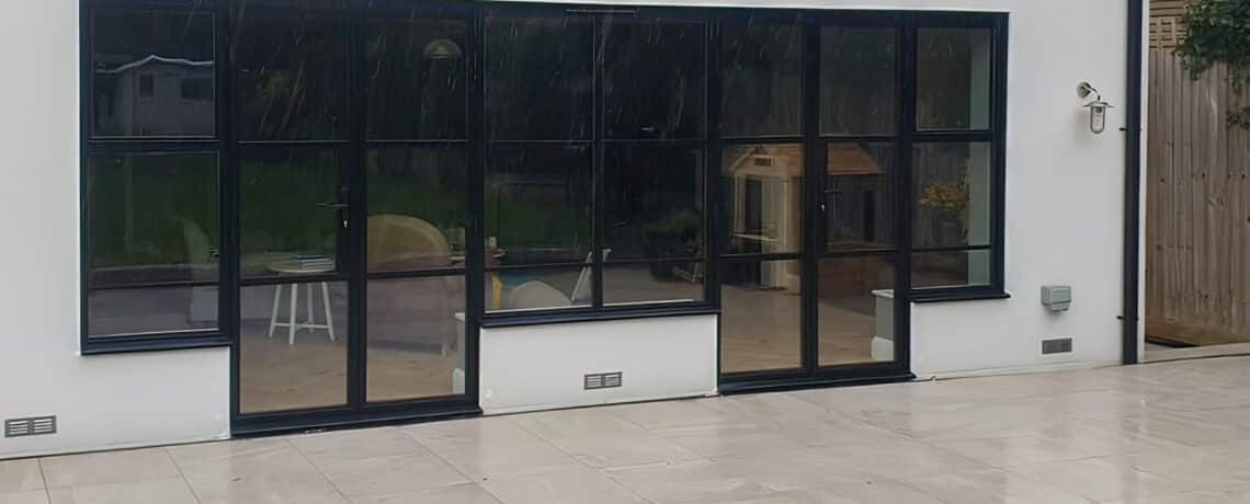 steel look patio doors in model house property renovation with marble patio slabs in front