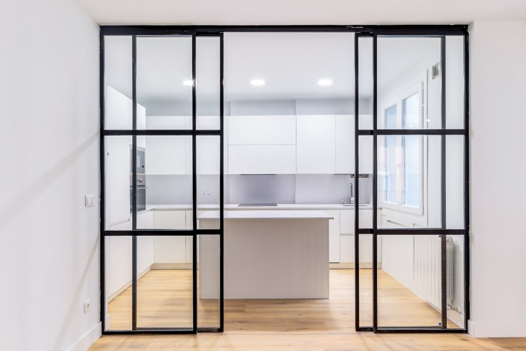 internal sliding doors separating a kitchen diner with wood floors