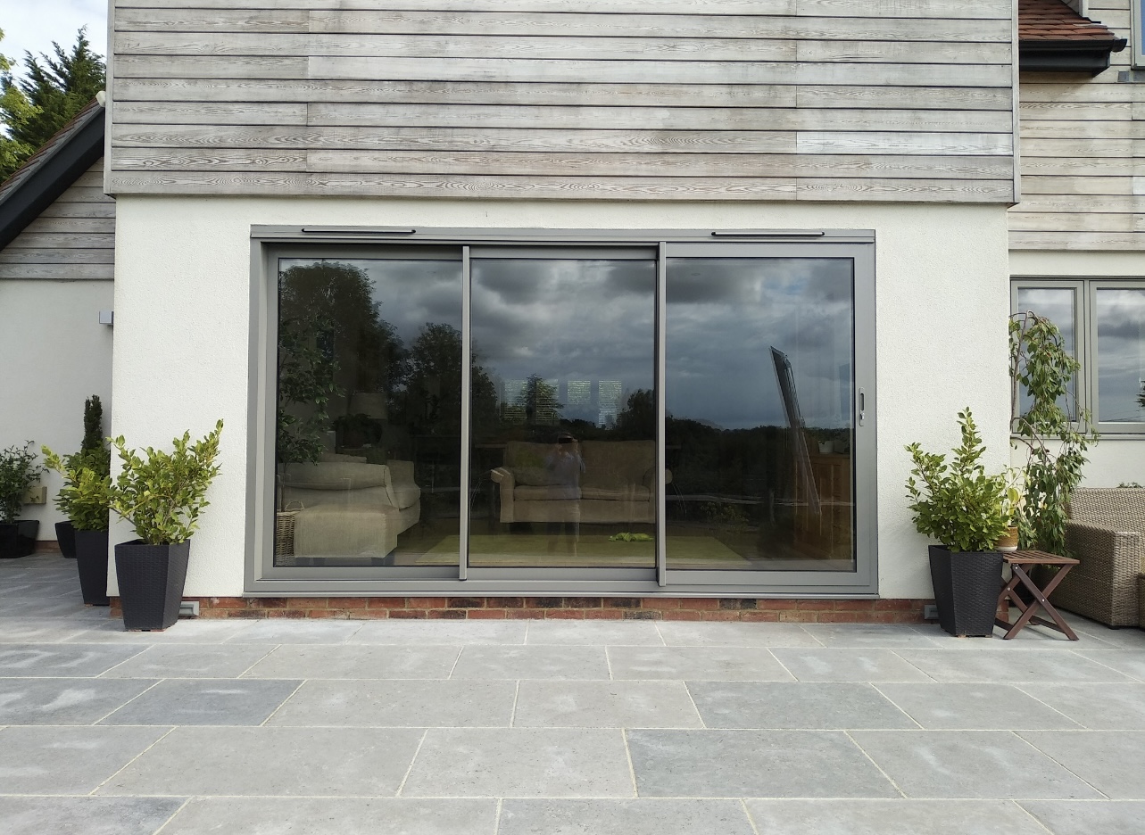 Visolgide sliding doors in light grey timber-clad extension