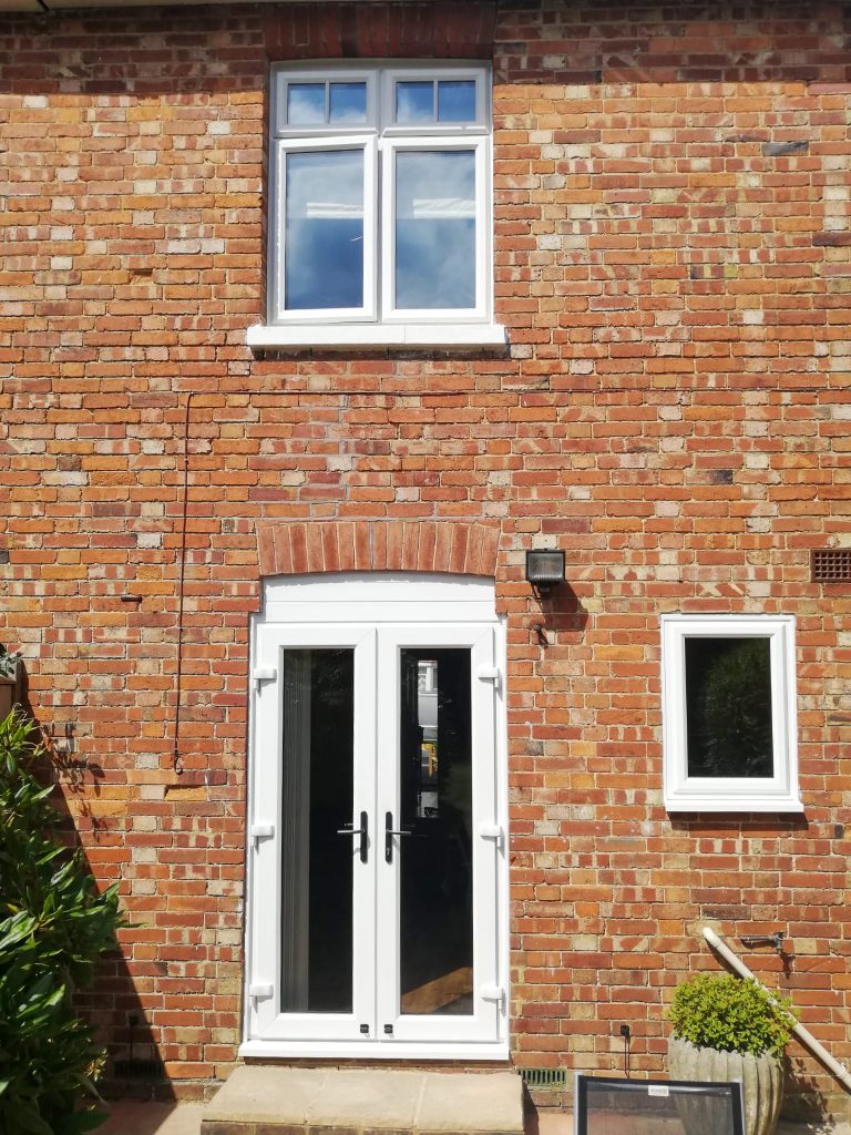 back elevation of a house showing patio doors and new windows.