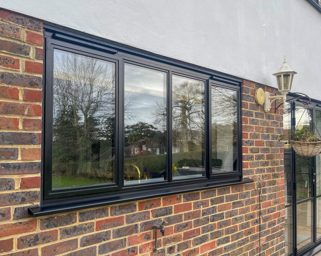 Outside view of four panel kitchen window in render and brickwork
