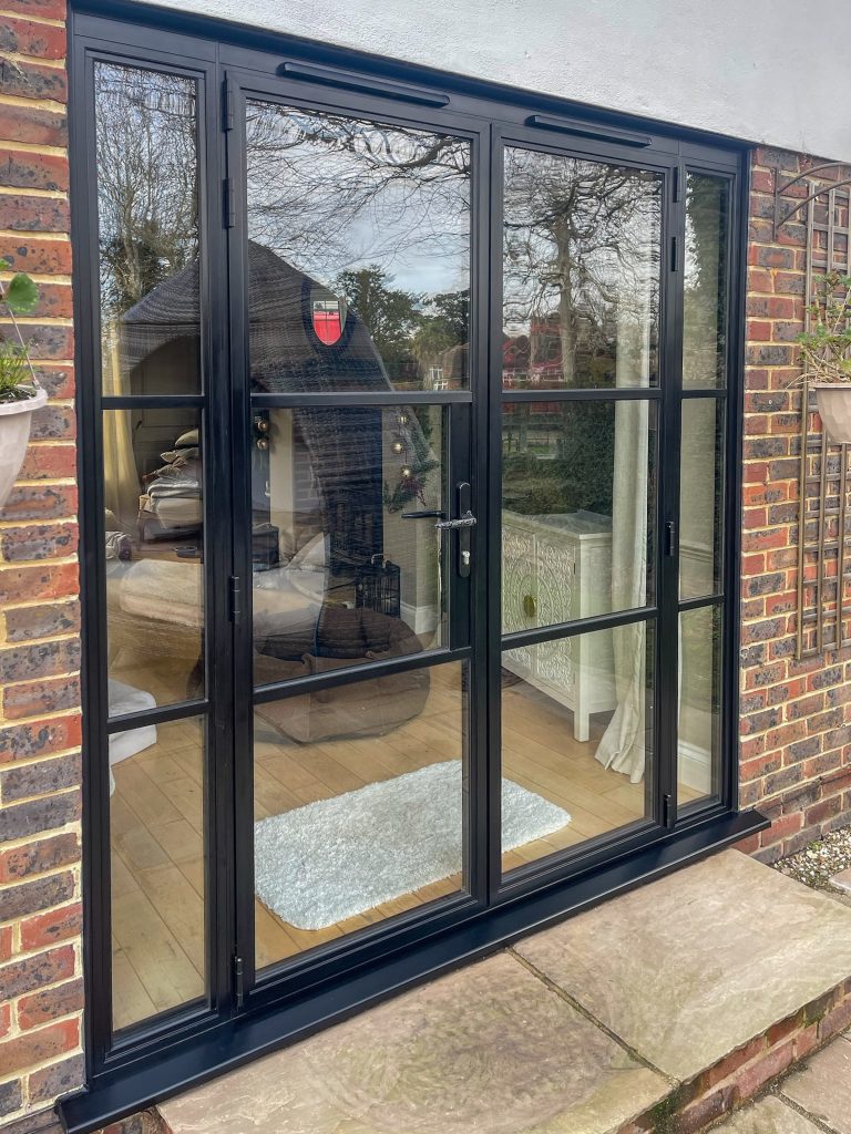 Heritage French doors with side panels, opening out to a patio area
