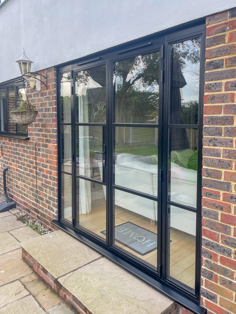 Heritage French doors with side panels, opening out to a patio area