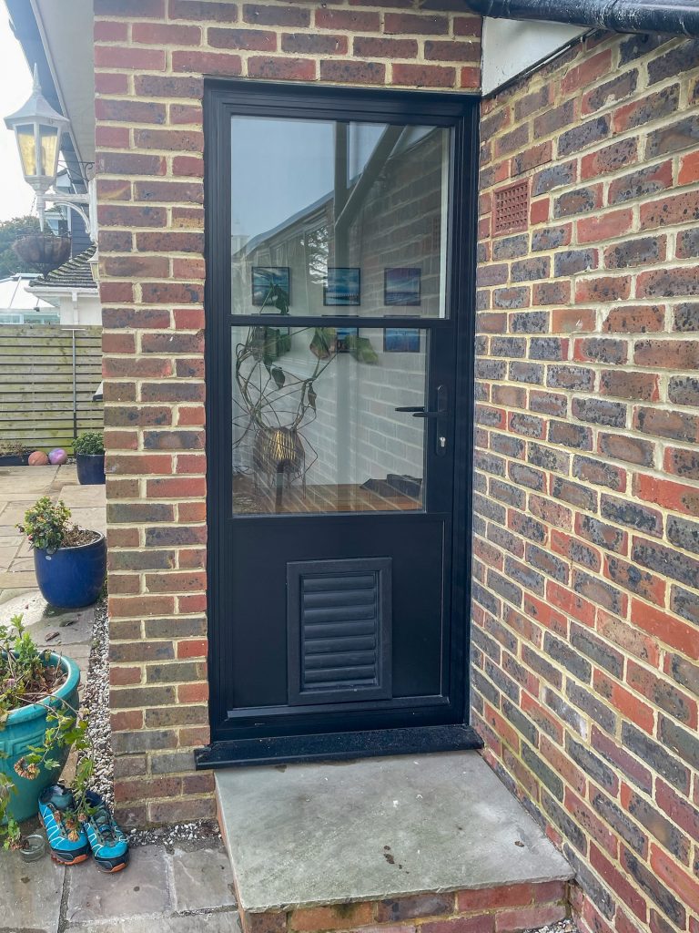 black steel look back door in the heritage style with glass above and bottom panel with pet flap