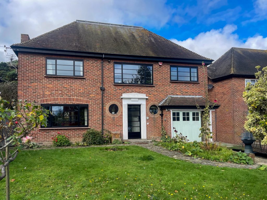 heritage aluminium windows and doors folkestone in a detached house with matching steel look front door porthole windows.