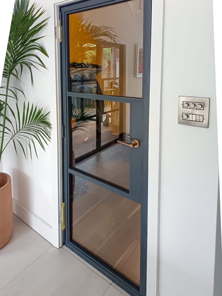 Aluspace internal doors as a single door with a spider plant and lounge view