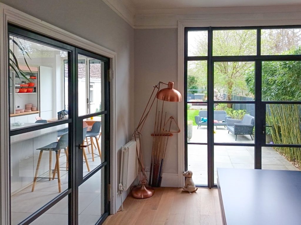 Black AluSpace heritage internal doors with brass handles between kitchen and dining room