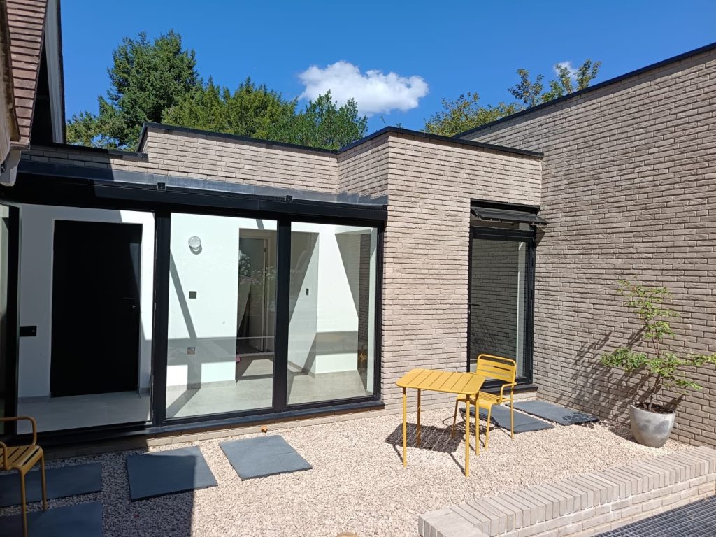 Modern brick courtyard with yellow table and chair